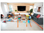 Kinderen spelen met Hot Wheels-baan met auto's, loops en stunts.