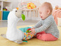 Een baby speelt met een Fisher-Price lama-speelgoed.