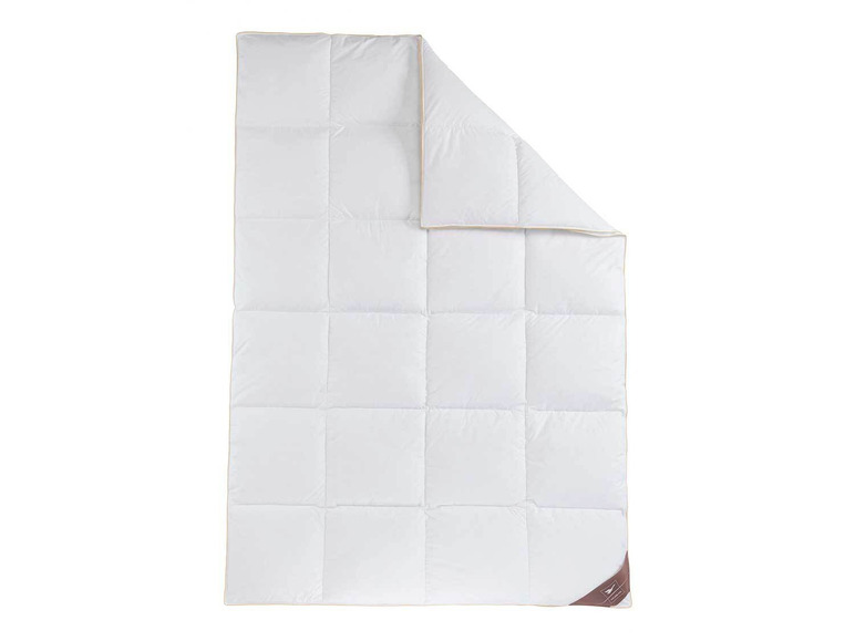 Een witte donsdeken met een beige bies.