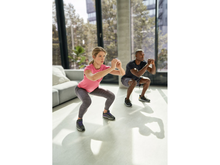 Twee personen doen squats tijdens een workout.