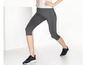 Grijs sportlegging en zwarte sportschoenen voor dames.