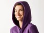 Een vrouw lacht in een paarse hoodie.