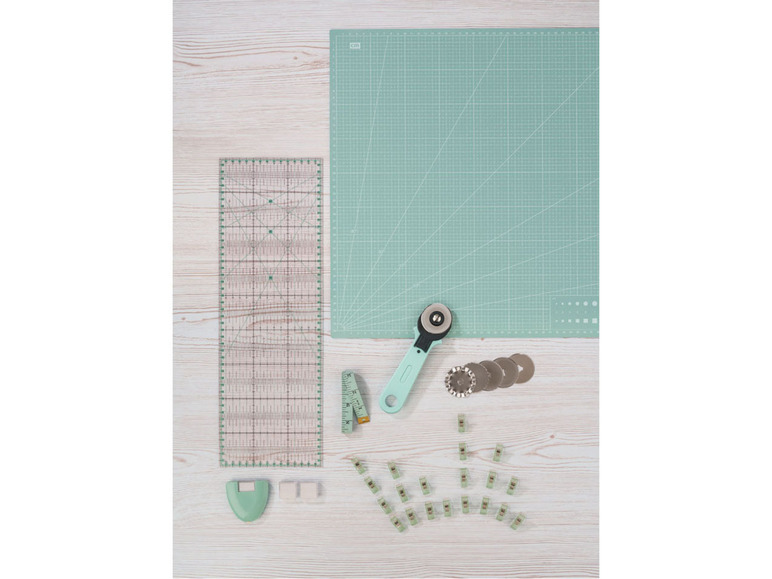 Een snijmat, rolmes, liniaal en andere benodigdheden voor naaien.