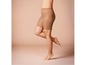 Vrouwelijke benen met beige panty's tot aan de bovenbenen.
