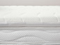 Een witte matras topper met een bedmatras eronder