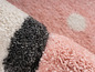 Roze, wit en grijs pluche tapijt met witte stippen.