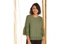 Een vrouw draagt een groene blouse met kantdetails.