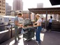 Een groep mensen geniet van een barbecue op een dakterras.
