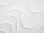 Close-up van een wit matras met een golvend patroon.