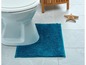 Een wit toilet met een blauwe badmat.