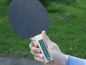 Een hand houdt een zwart tafeltennisbat van Schildkröt vast.