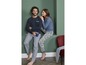 Man en vrouw in pyjama's, hij met een donkerblauwe longsleeve en grijze broek, zij met een blauwe longsleeve en broek met bloemenprint.