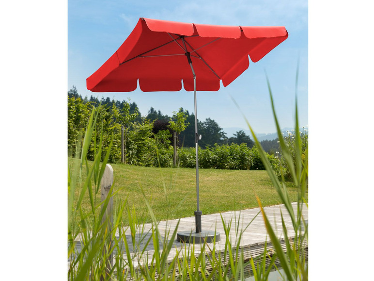 Een rode parasol op een houten terras.