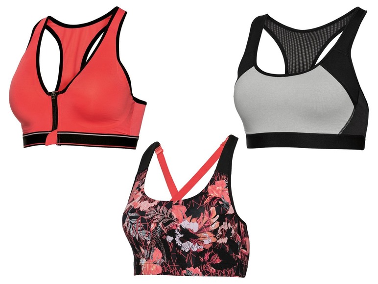 Drie sportbeha's: één roze met rits, één grijs met zwart en één met bloemenprint.