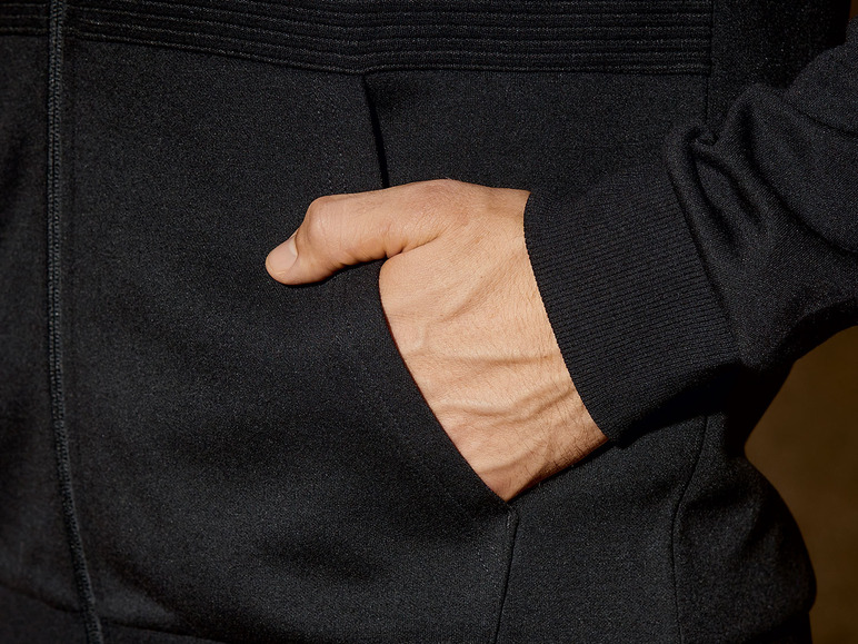 Een zwart jack met een zak, detail van de stof.