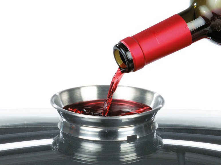 Rode wijn wordt in een metalen bakje gegoten.