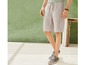 Man draagt ​​beige cargo shorts en donkergrijze canvas schoenen.