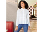 Een vrouw draagt een witte blouse en blauwe jeans.