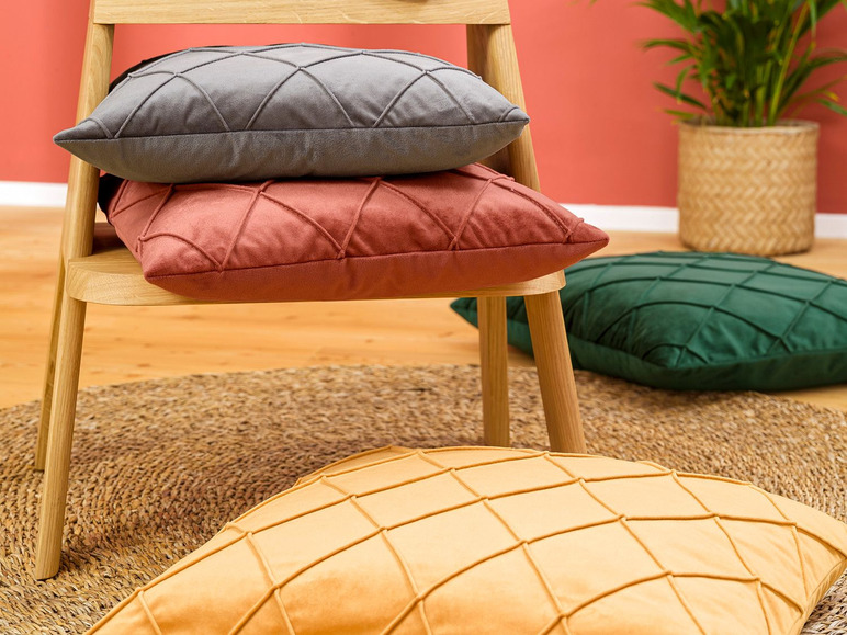 Grijze, roze en gele kussens op een houten stoel.