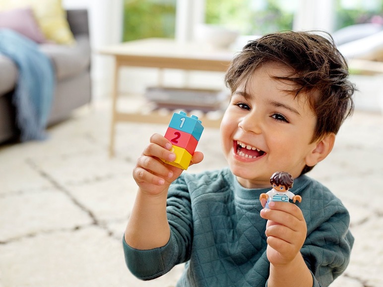 Een jongetje speelt met LEGO DUPLO blokken en een poppetje.