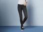 Een vrouw draagt zwarte skinny jeans en zwarte schoenen.