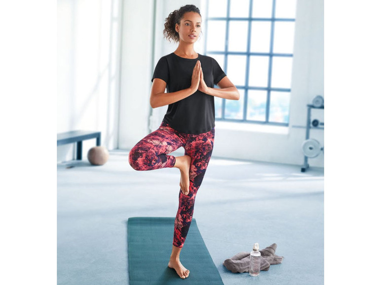 Vrouw doet yoga in sportkleding met een geprinte legging.