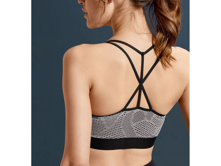 Een vrouw draagt ​​een grijze sportbeha met zwarte bandjes.