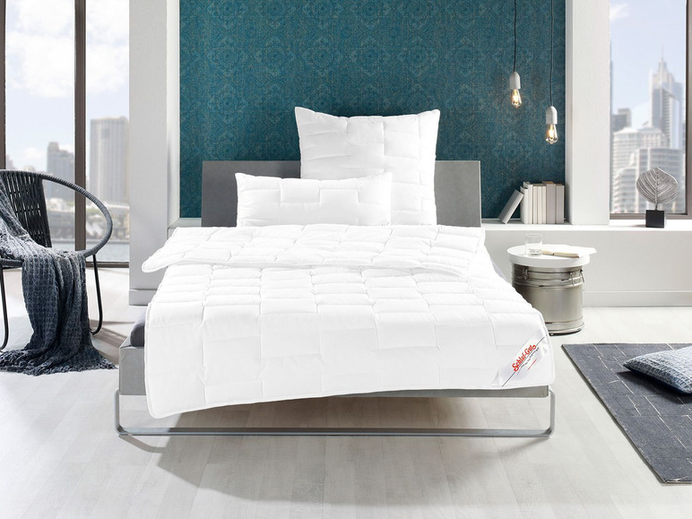 Een wit dekbed van Schlaraffia op een bed met kussens.