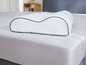Een wit kussen met memory foam op een bed.