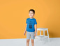 Een jongetje draagt een blauw T-shirt met Tom & Jerry print en grijze shorts.