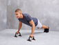 Man doet push-ups met behulp van push-up handvatten.