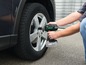 Een persoon gebruikt een Parkside schroevendraaier om een wiel te bevestigen.