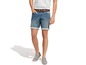Man draagt blauwe denim shorts en grijze schoenen.