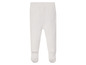Witte gebreide baby broek met voetjes.