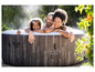 Een gezin geniet van een Lay-Z-Spa Bahamas opblaasbare hottub.