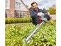 Een man trimmet een haag met een elektrische heggenschaar van Gardena.