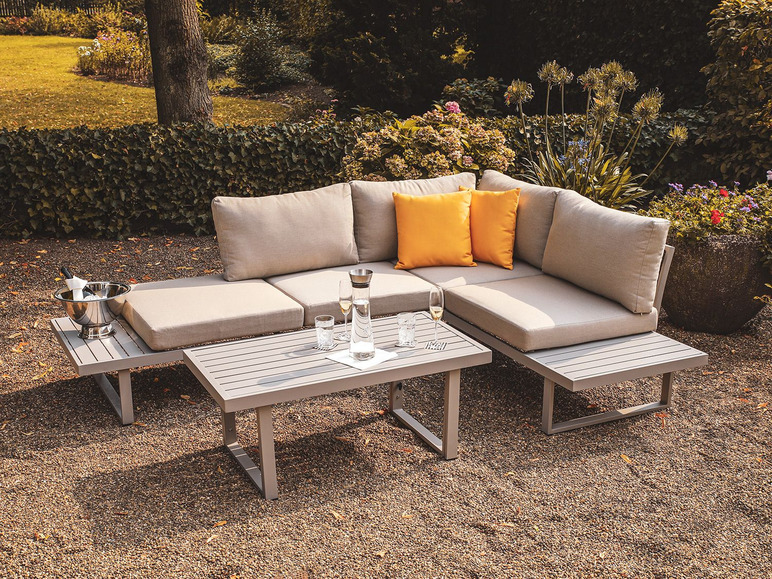 Een moderne loungeset met een hoekbank en bijzettafels in de tuin.