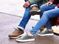 Twee personen dragen casual schoenen en jeans.