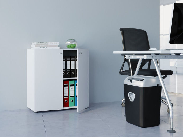 Een witte archiefkast met een bureau en een papierversnipperaar.