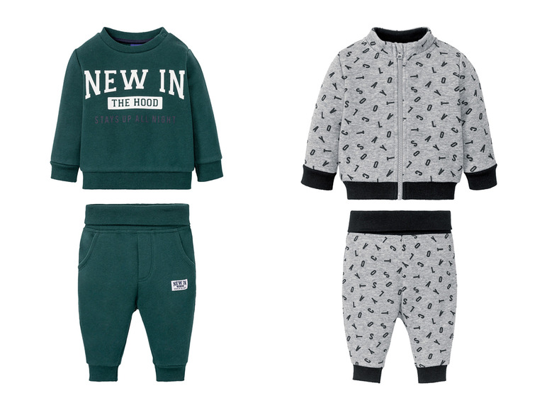 Twee babypakjes, een groene met 'New in' opdruk en een grijs met letterprint.