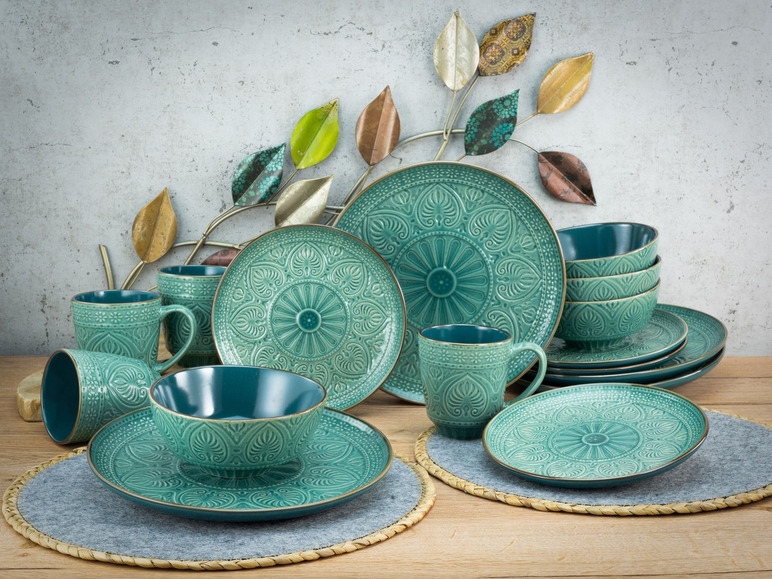Een set met turquoise serviesgoed met ingegraveerde patronen, waaronder borden, kommen en bekers.