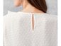 Witte blouse met stippen en een ronde hals.