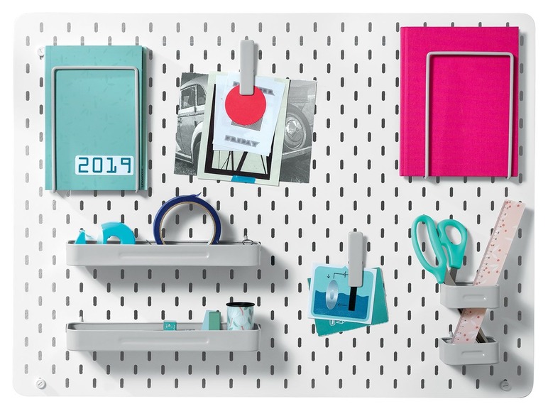Een geperforeerde wand met planken, een notitieboekje, een map, scharen en tape.