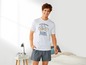Man in een wit T-shirt met fiets print en grijze shorts.