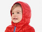 Een kind in een rode winterjas met capuchon.