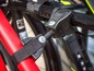 Een fietsdrager met een rode fiets bevestigd met zwarte banden.