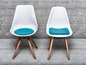 Twee witte stoelen met blauwe zitkussens.