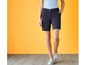 Een vrouw draagt ​​donkerblauwe shorts en witte sneakers.