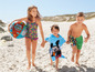 Kinderen op het strand met Paw Patrol zwembadbal, Mickey Mouse badjas en zwemkleding.