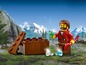 Een LEGO minifiguur met een schat en een krat in een bergachtig landschap.